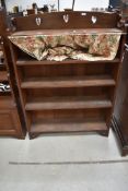 An Arts and Crafts dark oak bookcase with heart motif decoration