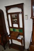A late 19th Century oak hall stand having mirror and part tiled back, compartment and double drip