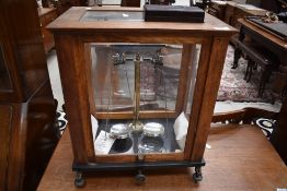 A traditional oak cased set of lab scale and cased set of weights