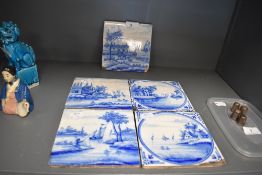 Five antique Dutch delft tiles depicting river side or canal scenes most having age related wear
