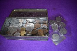 A selection of collectable world coins and currency in vintage tin