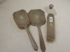 A three piece silver dressing table set having engine turned decoration and plain cartouche,