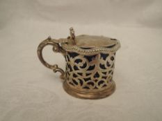 A Victorian silver lidded mustard pot having pierced decoration, moulded bow thumb rest and blue