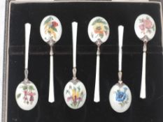 A cased set of six silver and enamel teaspoons having floral pictorial decoration to back of gilt