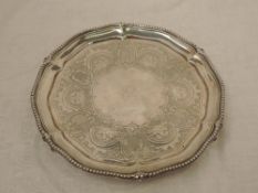 A Victorian silver salver having gadrooned pie crust rim, engraved decoration with central crest and