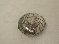 A white metal circular trinket box of oyster shell style having gilt interior and bearing marks to