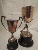 A silver trophy cup having a trio of shotgun rifles modelled as the stem with plain cup above with