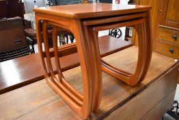A vintage teak nest of three stylised tables