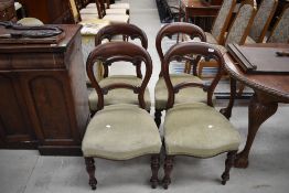 A set of four Victorian mahogany balloon back chairs having turned legs and later green dralon