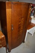 An early 20th Century oak small wardrobe, having semi bow front, width approx. 78cm
