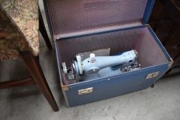 A vintage hand crank sewing machine, by Jones, in powder blue, with attachments and case