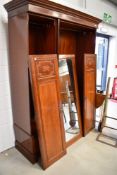 An Edwardian mahogany and inlaid mirror door triple wardrobe