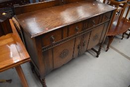 An early 20th Century dark oak ledgeback sideboard on barley twist legs, width approx. 122cm