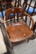 A late 19th or early 20th Century oak spindle back captains style office chair having turned frame