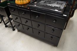 A vintage dark stained merchants style chest of four by three drawers