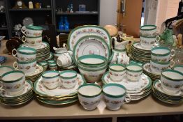 A large partial antique dinner service having hand tinted floral pattern, green banding and gilt