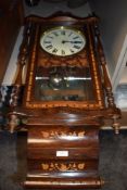 An American style wall clock having ornate casing with inlayed banding.