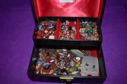 A small black jewellery box containing a selection of earrings etc