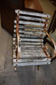 A vintage garden chair having slatted wooden seat and scrolled metal arms and feet.