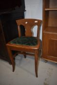 An interesting late 19th or early 20th Century golden oak stool having vase back and later