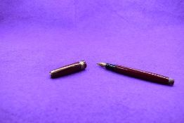 A Mabie Todd & Co Swan Leverless twist filler, in maroon with two narrow and one broad band to cap