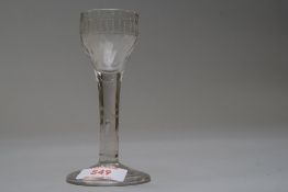 A wine glass having plain stem with a tear on a folded foot with fluted and etched decoration to