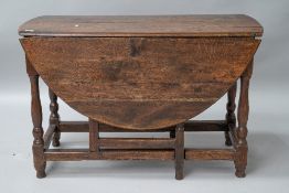 A period oak gateleg table having drawers to each end, on turned legs. Splitting to top and a few