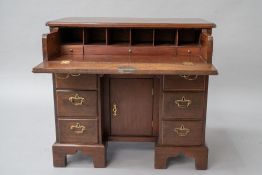A hardwood kneehole desk in the 19th Century style having pull out desk to frieze, brass drop