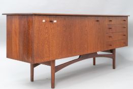 A vintage teak sideboard, in the Long John style , having wide drop flap cocktail or similar section