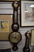 An antique banjo style barometer having a mahogany case with bulls eye mirror