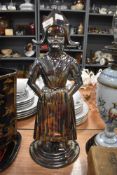 A fire side companion set holder in the form of a Dutch girl