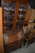 An early 20th Century reproduction bureau bookcase having astral glazed top and three drawer base