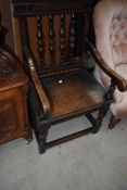 An unsual 19th Century oak and inlaid hall chair having turned spindle back and scroll arms
