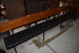 A vintage pew having wood frame and book rail to rear, with vinyl seat, length approx. 300cm