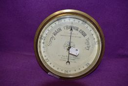A ships port hole style barometer having brass frame with thick cut glass by D Mc Gregor to the