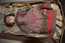 A vintage porcelain doll with box in Russian dress