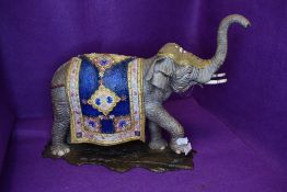 A large ceramic figure study of an Indian elephant dressed in ceremonial robes well detailed no