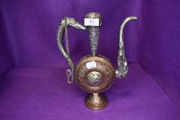 A middle eastern or Islamic style wine ewer having ornate copper embossed work