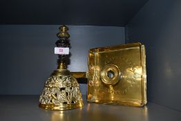 An antique brass square form chamber stick and an ornate dinner bell