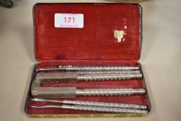 An Edwardian nutcracker and toothpick set having fine chase work decoration