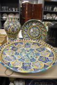 Three ceramic pieces hand decorated in Portuguese designs a large charger, wall plaque and vase