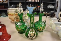 A selection of green glass decanters having decorative enamel work of flowers and butterfly with