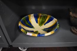 A large drip glazed studio pottery bowl with wave form decoration