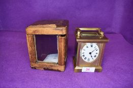 A brass cased carriage clock having a French movement with visible escape and oval enamel clock