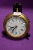 A wall clock in the form of a large pocket watch with brass case