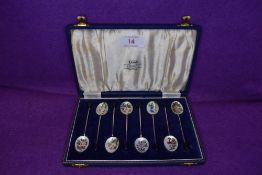 A cased set of eight Hm silver tea spoons being decorated with fine enamel work of garden flowers