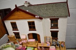 A child toy doll house with furniture and accessories in good condition