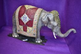 A large ceramic figure study of an Indian elephant dressed in ceremonial robes well detailed no