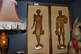 A pair of stylised mid century wooden plaques depicting man and woman