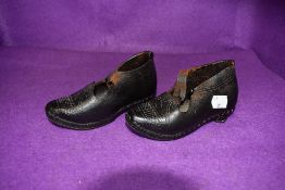 A pair of late Victorian school or childs clogs having leather and wooden bottom